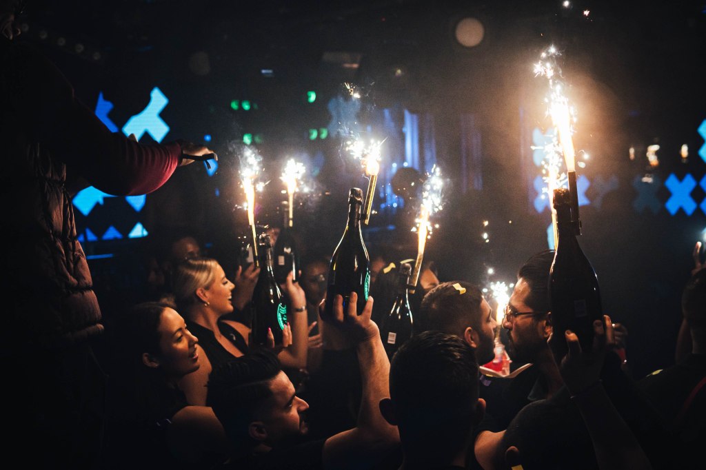 Tape Club champagne show with bottle girls carrying champagne bottles to a Tape Club table.
