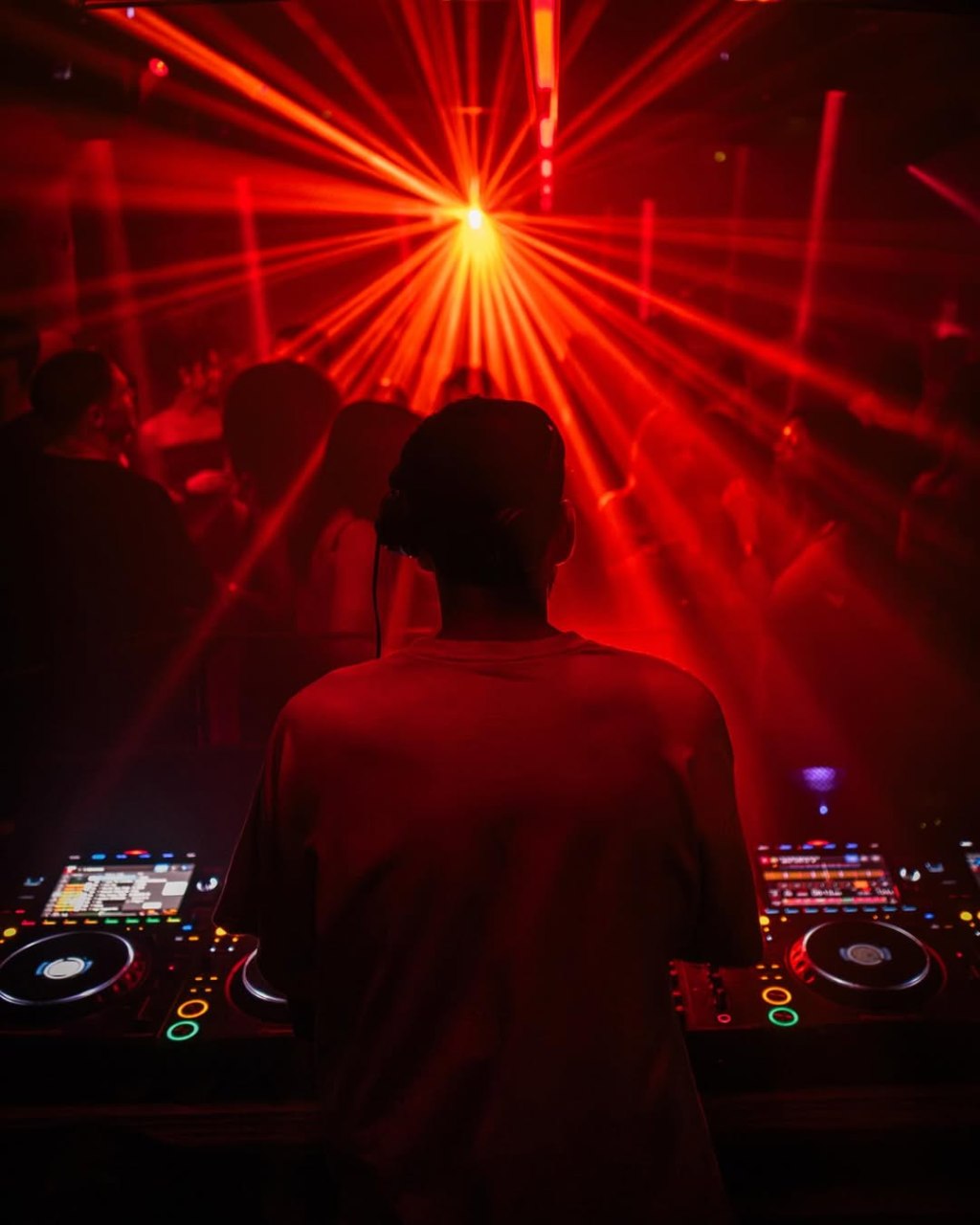 The view from a Beat London VIP table behind the DJ booth where you can see the DJ and the dance floor.