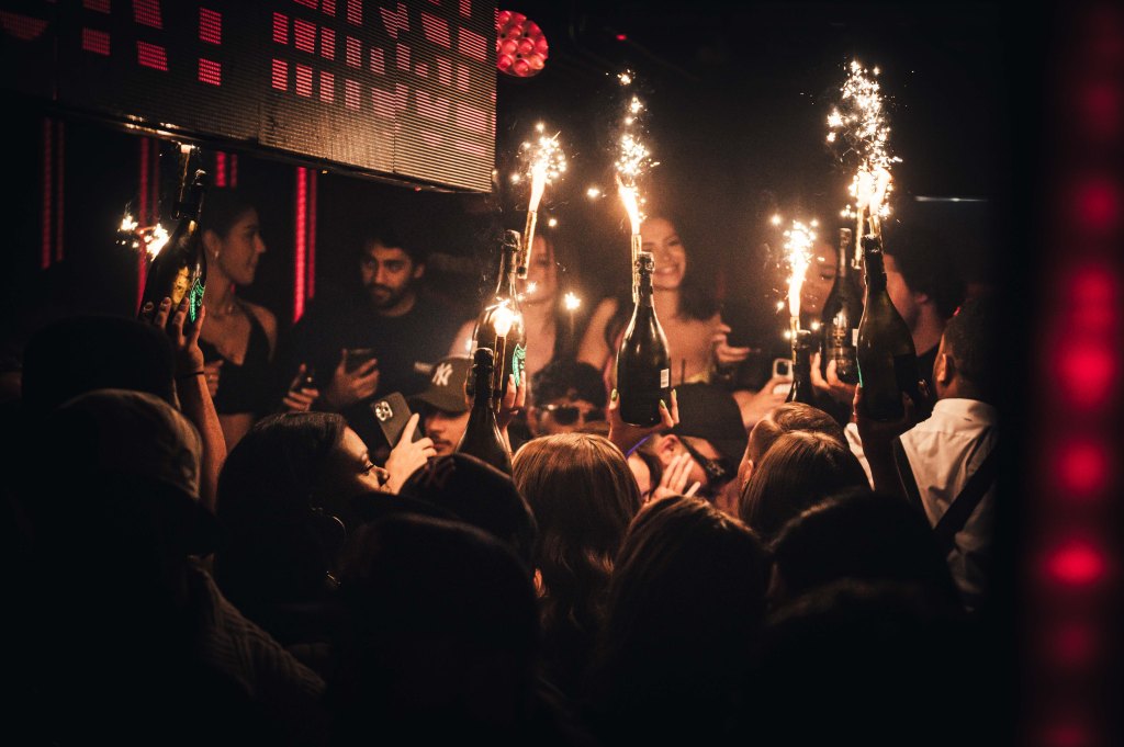 A Tape London VIP table watching bottle girls bring champagne bottles and sparklers to the tables for a champagne show.