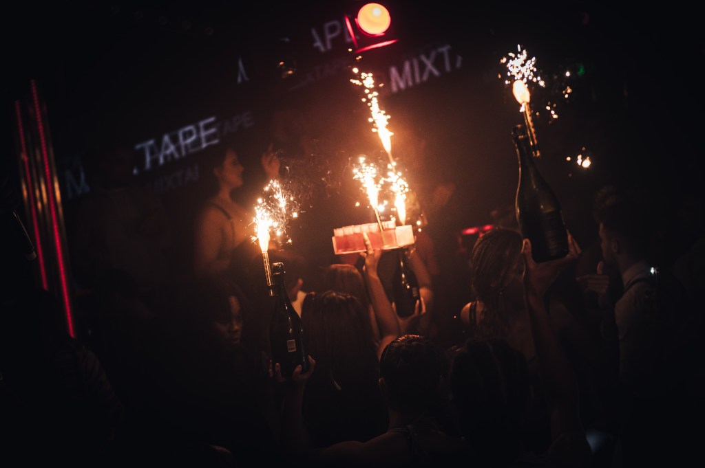 A bottle show with champagne bottles, a shot tray, and sparklers as part of a London club birthday package